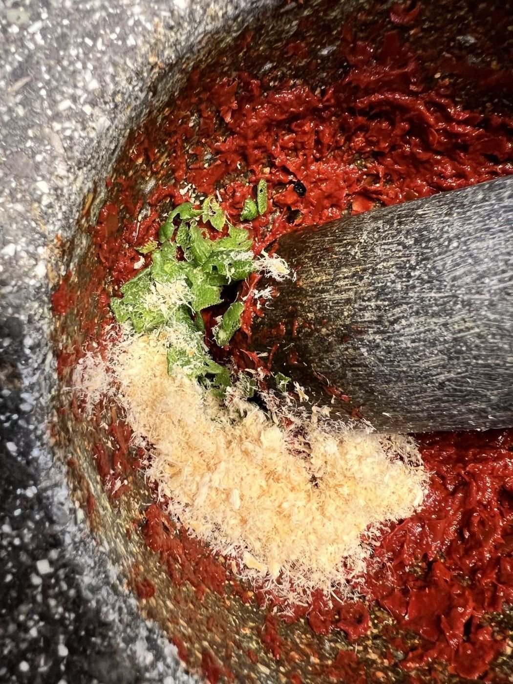 Curry paste being pounded in a stone mortar
